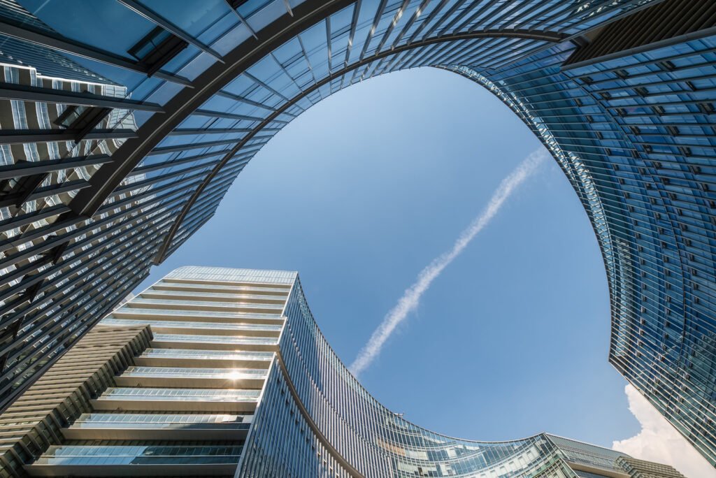 Modern curved glass buildings against clear blue sky