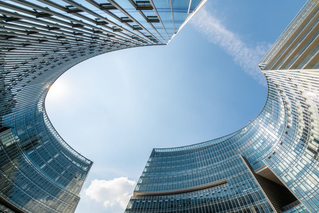 Modern curved glass buildings against clear blue sky