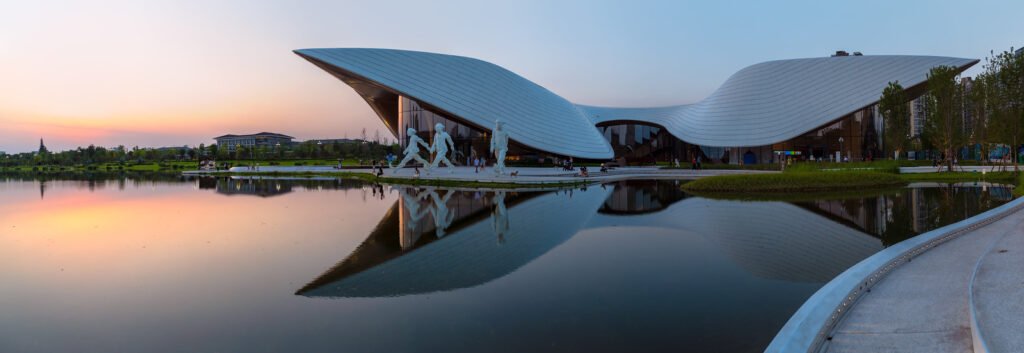 Chengdu Tianfu Art Museum reflecting in a lake at sunset panorama
