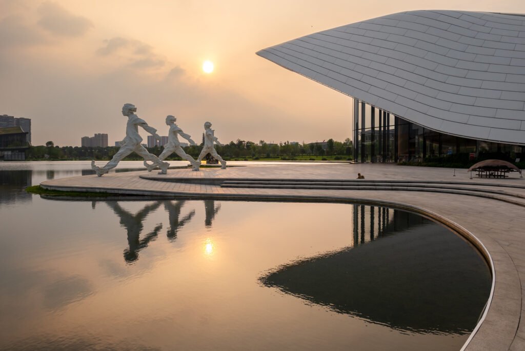 Chengdu Tianfu Art Museum reflecting in a lake at sunset