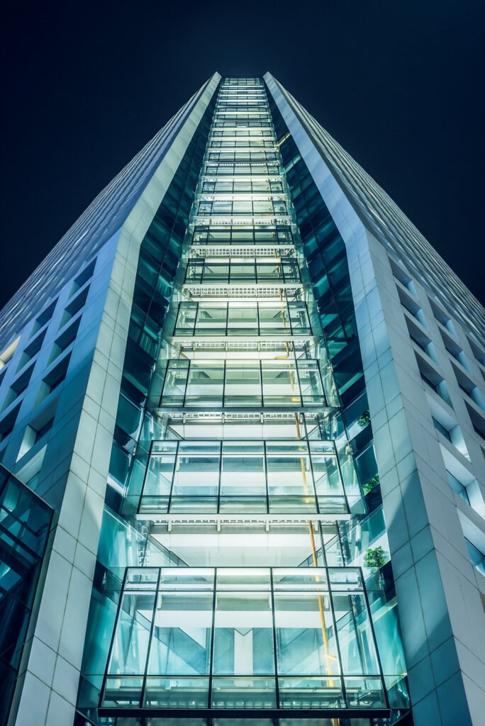 Modern skyscraper illuminated at night against sky