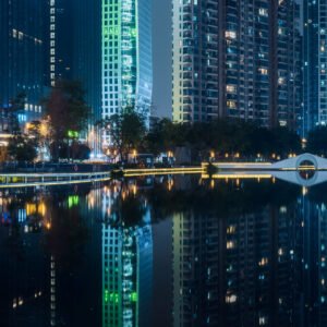 Illuminated skycrapers reflecting in a pond panorama at night