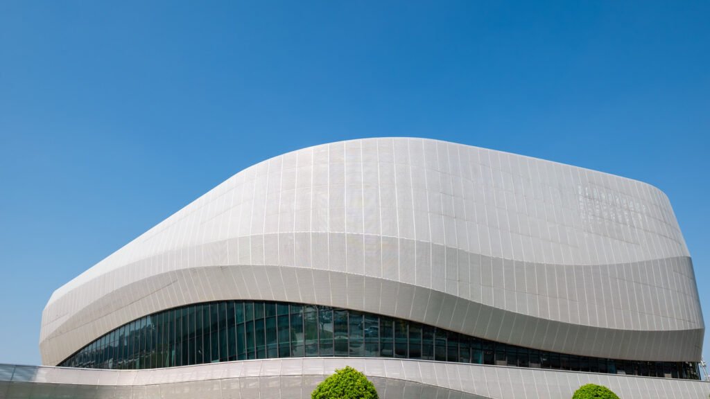 Futuristic architecture of modern building with blue reflective glass windows against clear blue sky