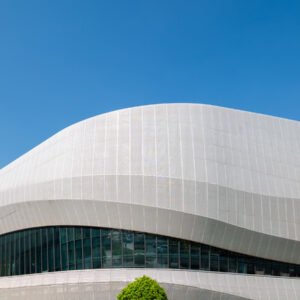 Futuristic architecture of modern building with blue reflective glass windows against clear blue sky