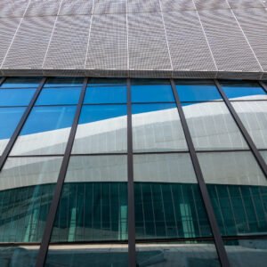Futuristic architecture of modern building with blue reflective glass windows against clear blue sky