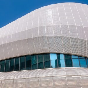 Futuristic architecture of modern building with blue reflective glass windows against clear blue sky