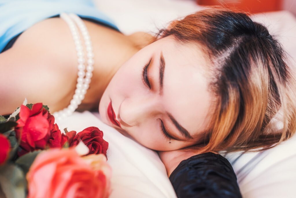 Beautiful woman sleeping on a bed of roses