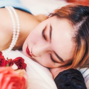 Beautiful woman sleeping on a bed of roses