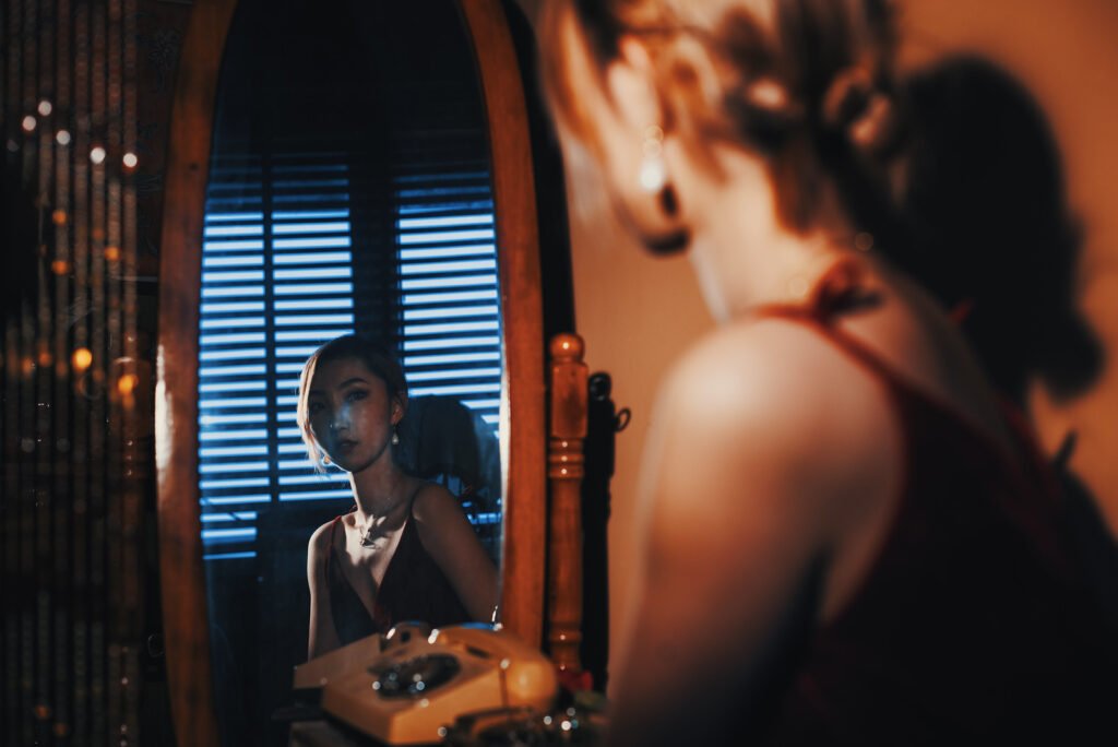 Young woman looking at her reflection in the mirror
