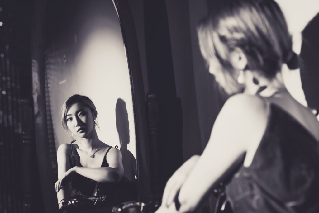 Young woman looking at her reflection in the mirror