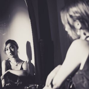 Young woman looking at her reflection in the mirror