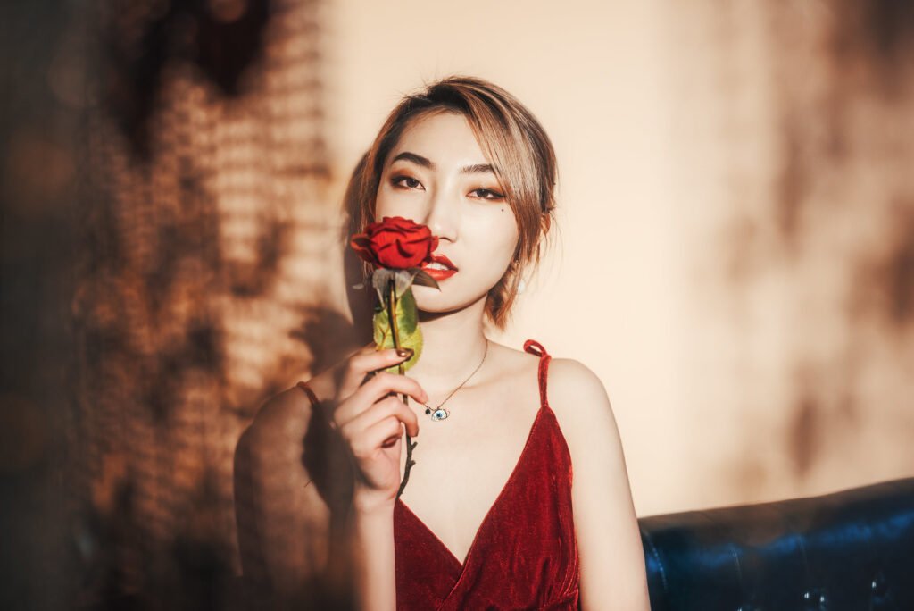 Portrait of a beautiful Asian woman holding a red rose