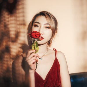 Portrait of a beautiful Asian woman holding a red rose